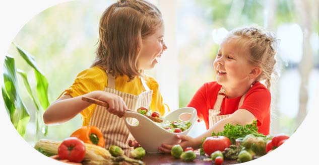 Niños cocinando, promoviendo nutrición infantil.